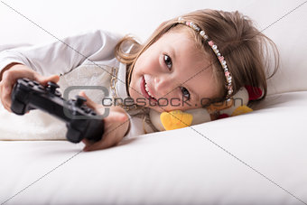 Smiling pretty little girl playing video games