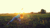 Beautiful young brunette woman doing yoga exercise on the field during amazing sunset.
