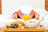 couple in bed, a tray of food in focus