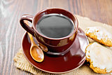 Coffee in brown cup with cookies on dark board