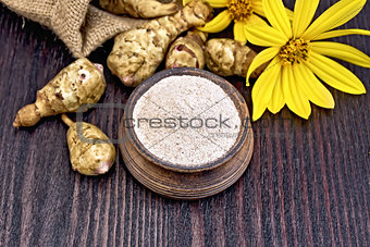 Flour of Jerusalem artichoke in clay bowl on board