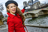 woman taking photo with mobile phone on embankment in Paris