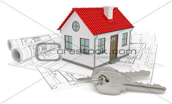 A model home and house key on blueprints