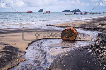 Old rusty barrel oil on beach in Asia