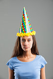 Woman looking with sadness while wearing party hat