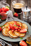 Homemade delicious pancakes served with fresh strawberries and h