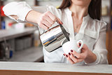 cup of coffee with milk in woman's hand