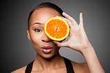 Happy healthy black asian woman with orange fruit