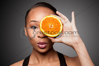Happy healthy black asian woman with orange fruit