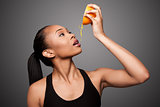 Happy healthy black asian woman squeezing orange juice fruit