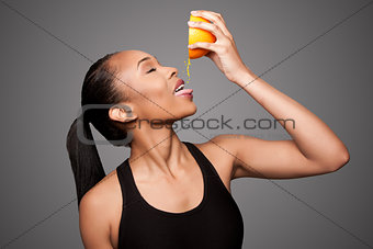 Happy healthy black asian woman squeezing orange juice fruit