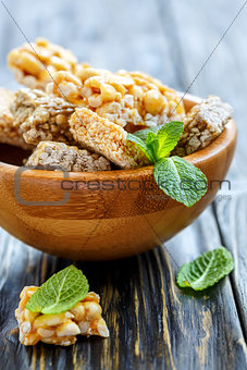 Wooden bowl with honey bars with peanuts, sesame seeds and sunfl
