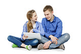 Teen boy and girl sitting with tablets