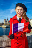 woman on embankment near Notre Dame de Paris showing flag