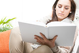 Attractive young woman reading a hardcover book