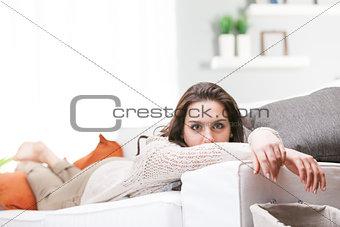 Young woman relaxing lying on a sofa