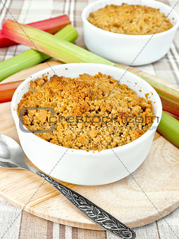 Crumble rhubarb in white bowl on linen tablecloths