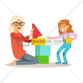 Girl And Grandmother Building Pyramid From Blocks, Part Of Grandparents Having Fun With Grandchildren Series