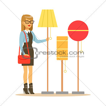 Woman Choosing A Living Room Lamp, Smiling Shopper In Furniture Shop Shopping For House Decor Elements