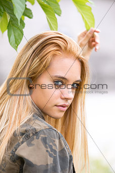 girl outdoors touching a leaf