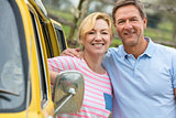 Happy Middle Aged Man and Woman Couple With Camper Van Bus