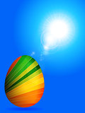 Striped Easter egg over sunny blue sky