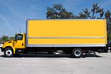A yellow box delivery truck with blue sky
