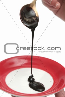 Drops of chocolate on the spoon and a plate