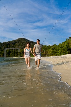 loving couple running along the beach