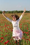 Girl jumps over poppy field