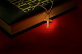 A gold cross necklace on a holy Bible