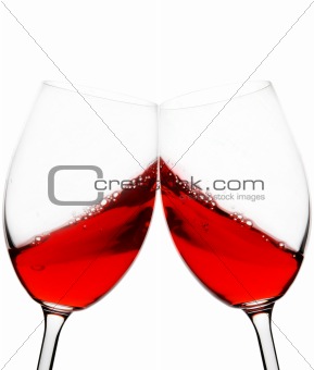 two red wine glasses raised in a toast