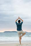 Man doing yoga on beach