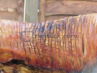 Charred flesh of a spit roasted pig