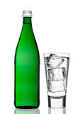 Green bottle of sparkling mineral water with glass