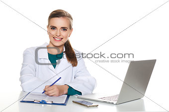 Young female student doctor sitting with a laptop on a white background