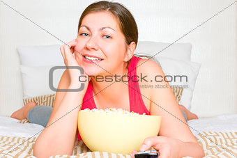 young brunette smiling and looking TV