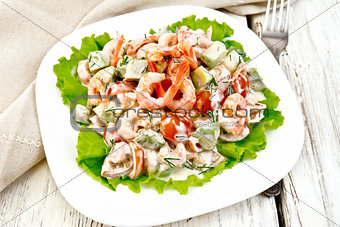Salad with shrimp and tomatoes in plate on board
