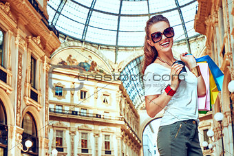 Smiling fashion woman with shopping bags and coffee cup