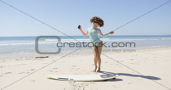Female listening music and dancing on beach