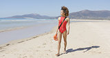 Female lifeguard walking along beach