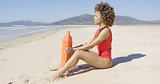 Lifeguard sitting with rescue float on beach