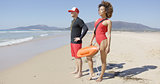 Female and male lifeguards posing on beach