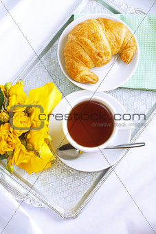 Morning breakfast with croissant and tea.