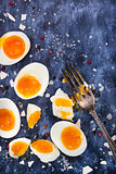Hard boiled eggs, sliced in halves on wooden table 