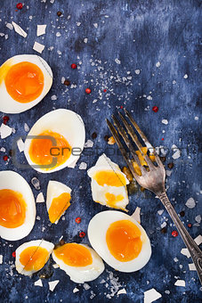 Hard boiled eggs, sliced in halves on wooden table 