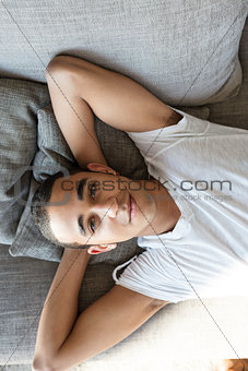Man relaxing on sofa and looking at camera