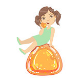 Little girl is sitting on a huge orange jelly andy, a colorful character