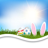 Easter background with eggs and bunny ears in grass 