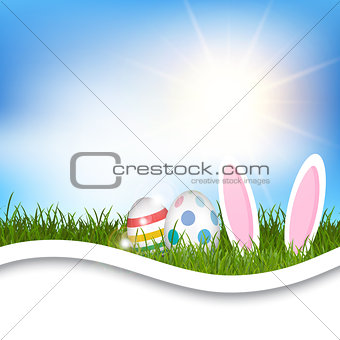 Easter background with eggs and bunny ears in grass 